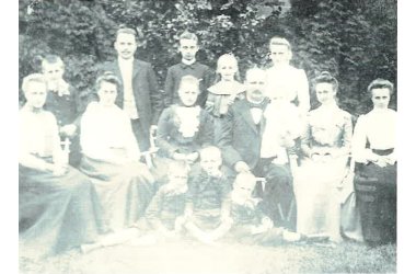 Die Familie Weltmann. Heinrich sitzt neben seiner Frau und sie sind umgeben von ihren 12 Kindern, 5 Jungen und 7 Mädchen.